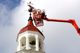 Joe Hollins and Richie Belliveau of Tip Top Construction return the historic weathervane to the top of the Steeple Building. Joe Hollins and Richie Belliveau of Tip Top Construction return the historic weathervane to the top of the Steeple Building.